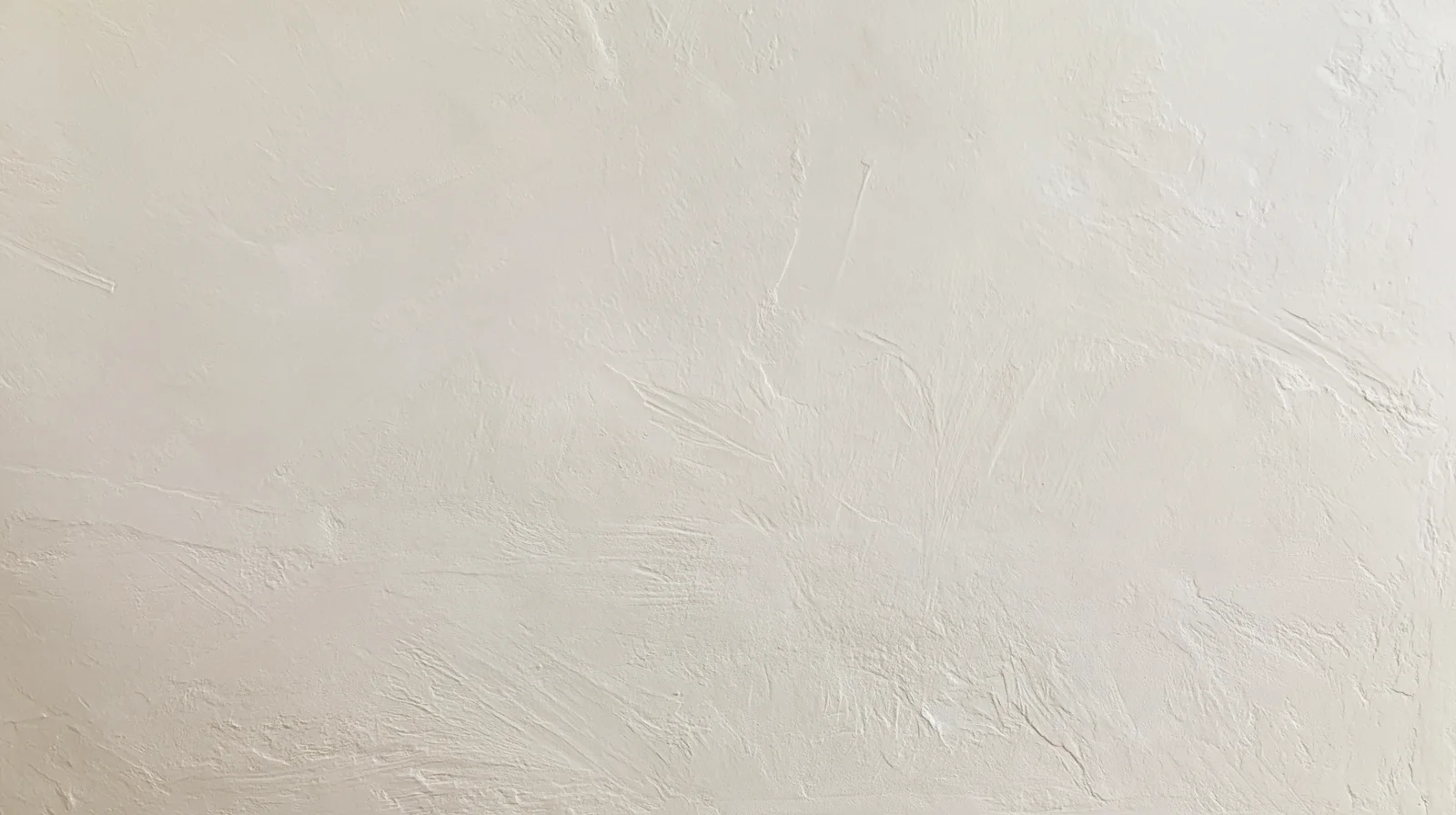 Freshly skim-coated plaster wall in soft daylight
