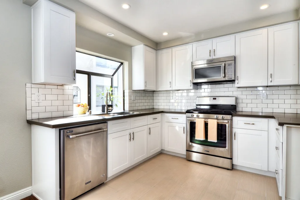 White kitchen with subway tile backsplash and stainless appliances