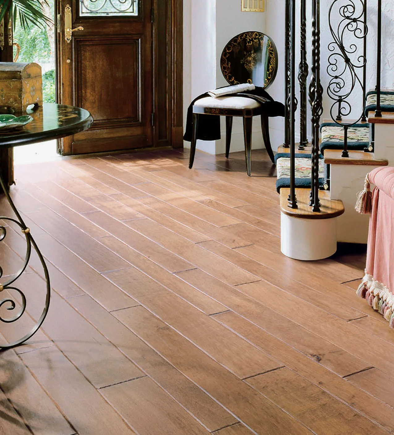Wide-plank wood flooring beside a staircase