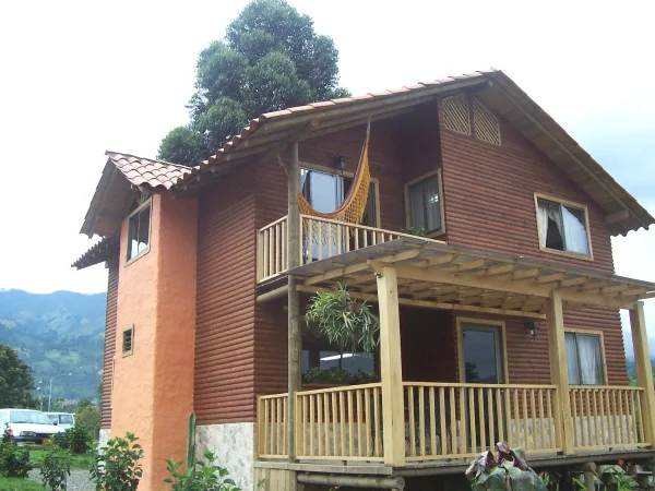 Two-storey timber cottage with a balcony and covered porch