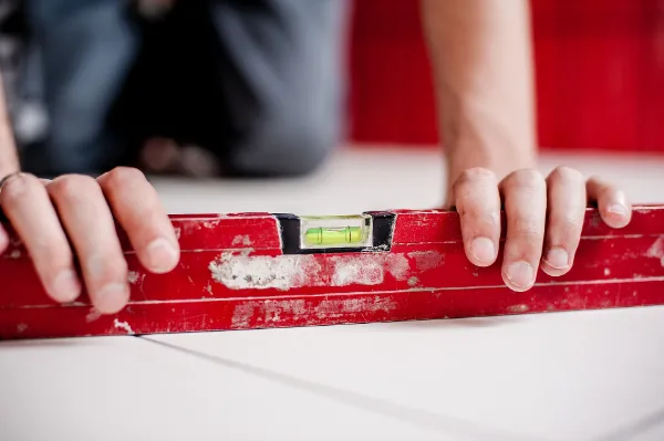 Hands checking a surface with a red spirit level